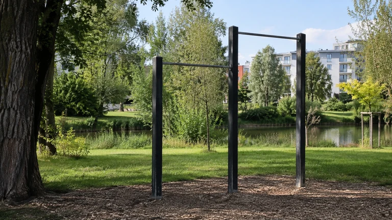 Des barres d’entraînement en plein air se trouvent au bord d’une allée arborée. Illustration générée par IA pour rbreak.com.